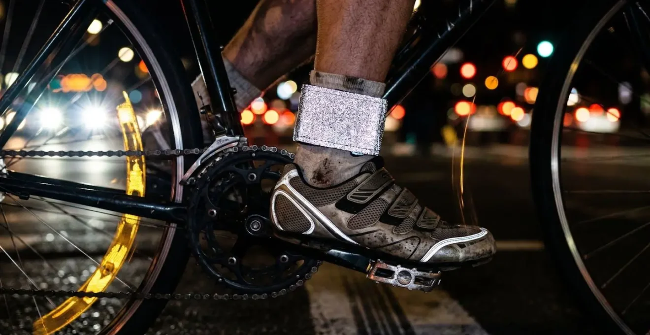 Cycliste équipé d'éléments réfléchissants sur les articulations traversant une intersection urbaine