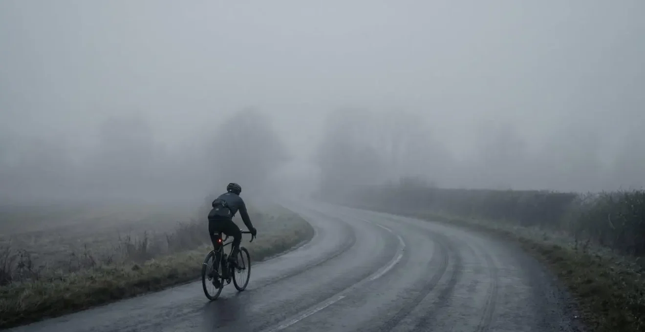 Cycliste pédalant dans un brouillard dense symbolisant la zone grise d'entraînement